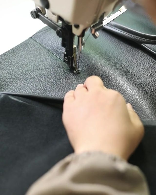 ミシンで本革を縫製する手元